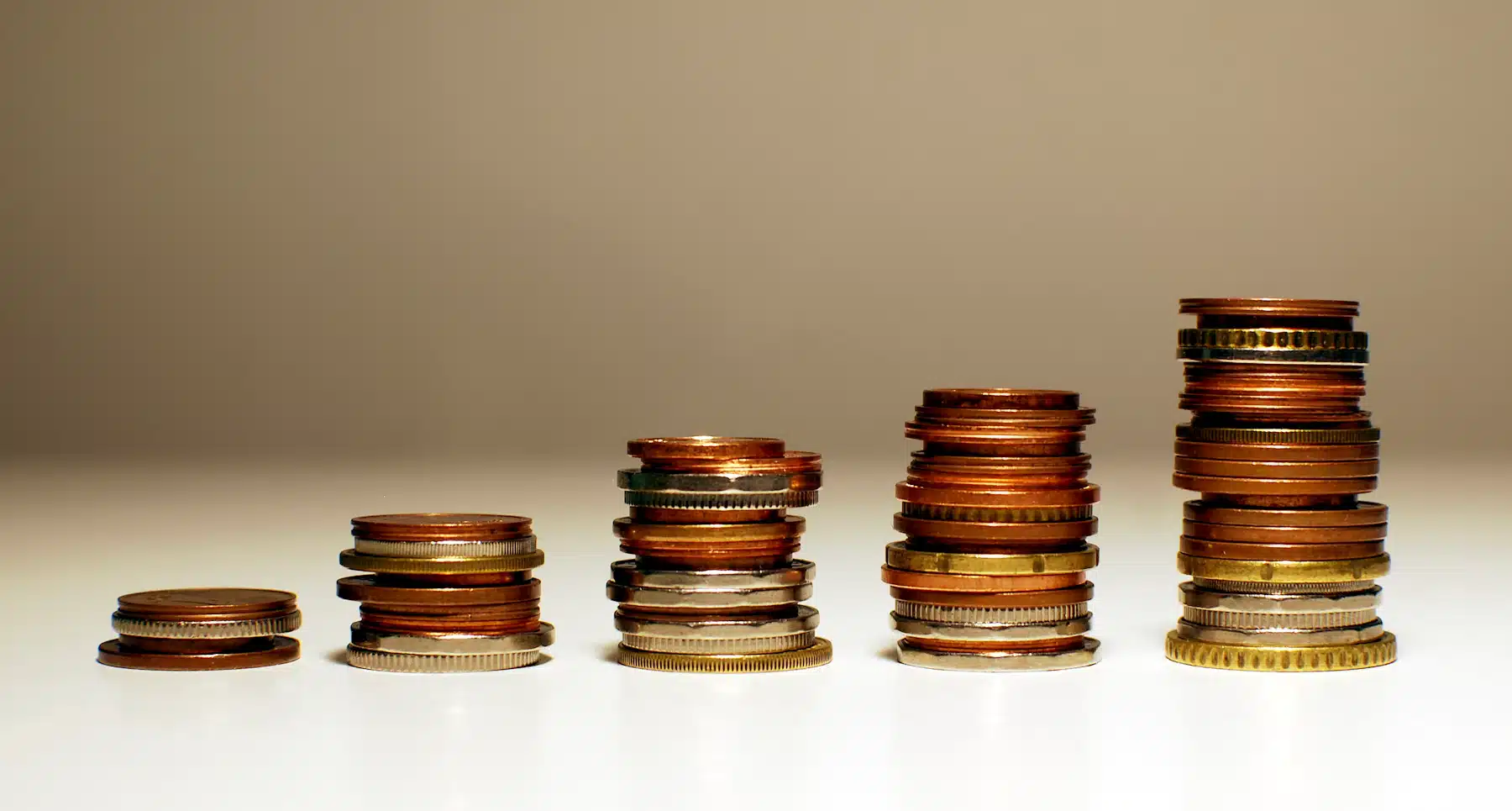 Stacks of coins rising in height Stacks of coins increasing in height from left to right