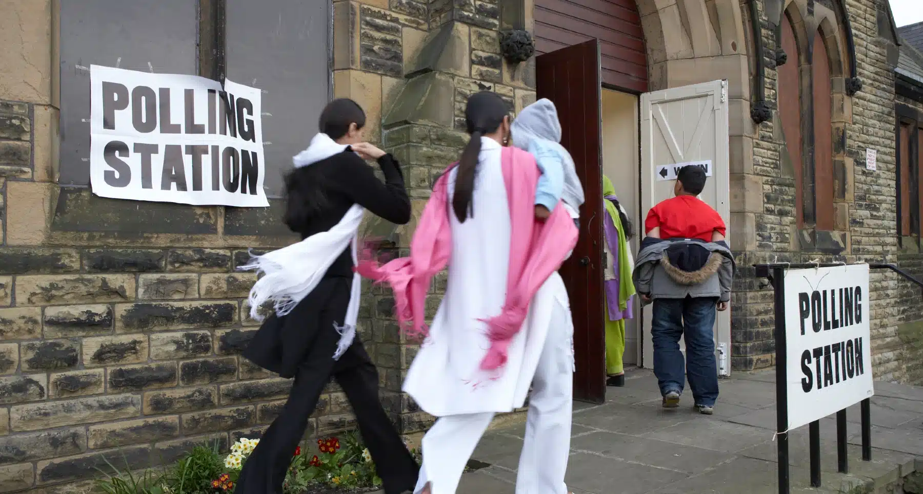 iStock-1033811022 A family arriving at a polling station to vote